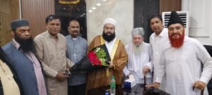 Shahzad Lawrence presenting flowers to Hafiz Tahir Ashrafi